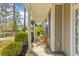 Inviting front porch with seating, classic columns, manicured landscaping, and charming details at 8961 N Red Maple Cir, Summerville, SC 29485