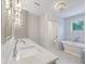 Bright bathroom with double sinks, marble countertop, chandelier, soaking tub, and separate water closet at 9 Marsh Island Ln, Isle of Palms, SC 29451