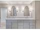 Bathroom featuring double sinks with marble countertop, custom cabinets, and stylish mirrors and lighting at 9 Marsh Island Ln, Isle of Palms, SC 29451