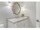 Bright bathroom features an decorative rope mirror, stone countertops, and traditional fixtures at 9 Marsh Island Ln, Isle of Palms, SC 29451