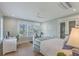 Bright bedroom with a dedicated workspace, white trim, shutters, and a modern ceiling fan at 9 Marsh Island Ln, Isle of Palms, SC 29451