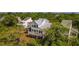 Beautiful home exterior, featuring a metal roof, a spacious deck, and mature trees for added privacy at 9 Marsh Island Ln, Isle of Palms, SC 29451