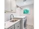 Bright laundry room with tile floors, storage cabinets, sink, countertop, and washer/dryer at 9 Marsh Island Ln, Isle of Palms, SC 29451