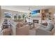 Cozy living room featuring a fireplace, large windows, neutral furniture, and a ceiling fan at 9 Marsh Island Ln, Isle of Palms, SC 29451