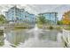 Picturesque view of the condos overlooking a pond with a fountain at 9 Marsh Island Ln, Isle of Palms, SC 29451