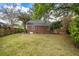 Green backyard featuring brick home, fence, and grass at 1 Colleton Dr, Charleston, SC 29407