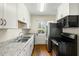 Galley kitchen featuring stainless steel appliances, white cabinets and granite countertops at 1 Colleton Dr, Charleston, SC 29407