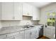 Bright kitchen with white cabinets, granite countertops and stainless dishwasher at 1 Colleton Dr, Charleston, SC 29407