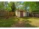 Spacious backyard featuring lush green grass, mature trees, and a storage shed at 100 Nighthawk Ln, Summerville, SC 29485