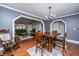 Open-concept dining area featuring hardwood floors, modern chandelier, and easy access to the living room at 100 Nighthawk Ln, Summerville, SC 29485