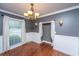 Charming dining room boasts wainscoting, hardwood floors, and a stylish chandelier at 100 Nighthawk Ln, Summerville, SC 29485