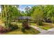 Scenic view of a brick home surrounded by lush trees, a driveway, and a beautifully landscaped lawn at 100 Nighthawk Ln, Summerville, SC 29485