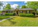 Charming single-story home featuring a well-manicured lawn, brick accents and lush landscaping at 100 Nighthawk Ln, Summerville, SC 29485