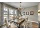 Inviting dining room features a wooden table, upholstered chairs, a modern chandelier, and large windows at 1000 Winding Grove Ln, Moncks Corner, SC 29461