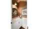 Stylish powder room showcasing a round mirror, textured wallpaper, and a marble-topped vanity at 1012 Ashley Ave, Charleston, SC 29403