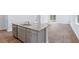 An island featuring gray cabinets, a granite countertop, a stainless steel dishwasher, and a sink overlooks the spacious living area at 1064 Forrest Creek Dr, Summerville, SC 29483