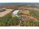 Stunning aerial view of a vast property featuring a serene lake surrounded by lush greenery and open fields at 1068 Witherbee Rd, Moncks Corner, SC 29461