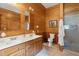 Warm wood paneled bathroom with double sink vanity and walk-in shower at 1068 Witherbee Rd, Moncks Corner, SC 29461