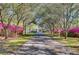 A picturesque tree-lined driveway leads to a charming home with blooming azaleas at 1068 Witherbee Rd, Moncks Corner, SC 29461