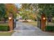 Gated driveway leading to charming home with beautiful landscaping and mature trees at 1068 Witherbee Rd, Moncks Corner, SC 29461