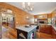 This kitchen features wood paneling, a granite countertop, and a view into the living space and brick fireplace at 1068 Witherbee Rd, Moncks Corner, SC 29461