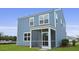 View of the blue sided house from the backyard with a screened in porch at 114 Midmills Ln, Summerville, SC 29486