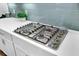 Close-up of a stainless steel gas stovetop with white quartz countertops and light blue subway tile backsplash at 1160 Old Field Dr, Summerville, SC 29483