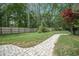 Lush backyard featuring a winding stone path leading through the garden, surrounded by mature trees and greenery at 118 Elery Ter, Summerville, SC 29485
