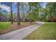 Suburban home with long driveway surrounded by manicured lawns, trees, and landscaping at 118 Elery Ter, Summerville, SC 29485