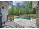 Backyard pool featuring stone surround, waterfall feature, and a wooden deck area with striped outdoor rug at 118 Elery Ter, Summerville, SC 29485