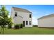 Backyard featuring a white two-story home, green grass, and landscaping at 118 Lilac Grove Way, Summerville, SC 29486