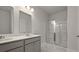 Modern bathroom featuring double sinks, a vanity with gray cabinets, and a glass-enclosed shower with marble-like floors at 118 Lilac Grove Way, Summerville, SC 29486