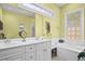 Well-lit bathroom featuring a double vanity, soaking tub, and a large mirror at 1188 Quick Rabbit Loop, Charleston, SC 29414