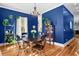 Bright dining room featuring elegant chandelier, dark table, hardwood floors, and vibrant blue walls at 1188 Quick Rabbit Loop, Charleston, SC 29414