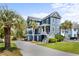 Charming two-story home with a well-manicured lawn and palm trees in the front yard at 1188 Quick Rabbit Loop, Charleston, SC 29414