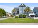 Blue two-story home with manicured lawn, white picket fence, and palm trees offering charm and curb appeal at 1188 Quick Rabbit Loop, Charleston, SC 29414