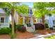 Charming yellow two-story home featuring a cozy porch with decorative plants and lush landscaping at 1243 Appling Dr, Mount Pleasant, SC 29464