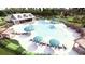 An aerial view of a large pool area with lounge chairs, umbrellas, and a shaded pavilion at 131 Lilac Grove Way, Summerville, SC 29486