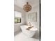 Bright bathroom featuring a standalone tub with modern light fixture and marble floors at 1412 Jackson St, Mount Pleasant, SC 29464
