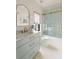 Stylish bathroom with marble countertops, blue vanity, and a shower-tub combination with glass doors at 1412 Jackson St, Mount Pleasant, SC 29464