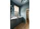 A butler's pantry has teal walls, marble countertop, dark cabinets, hardwood flooring and brass accents at 1412 Jackson St, Mount Pleasant, SC 29464
