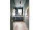 A butler's pantry with teal walls, marble countertop, dark cabinets, hardwood flooring and brass accents at 1412 Jackson St, Mount Pleasant, SC 29464
