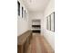 Hallway with wood floors, a long wooden console, and a view into a bedroom with a black bed frame at 1412 Jackson St, Mount Pleasant, SC 29464