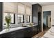 Kitchen featuring dark cabinetry, marble countertops, stainless steel sink, and large windows offering outdoor views at 1412 Jackson St, Mount Pleasant, SC 29464