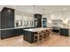 Modern kitchen with dark cabinets, marble countertops, large island with seating, and stainless steel appliances at 1412 Jackson St, Mount Pleasant, SC 29464