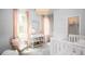 Bright Bedroom featuring a white crib, wicker chair, and soft pink accents for a warm atmosphere at 1431 Clay Field Trl, Summerville, SC 29485
