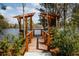 Wooden dock and bench overlooking a serene lake surrounded by lush greenery and trees at 1433 Clay Field Trl, Summerville, SC 29485