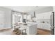Bright, modern kitchen featuring a large island with seating, white cabinets, and stainless steel appliances at 1433 Clay Field Trl, Summerville, SC 29485