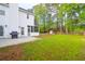A view of the home's rear exterior, including a spacious yard with a firepit and seating area at 144 Jupiter Ln, Summerville, SC 29483
