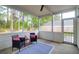 Cozy screened porch featuring comfortable seating and a view of the wooded backyard at 144 Jupiter Ln, Summerville, SC 29483